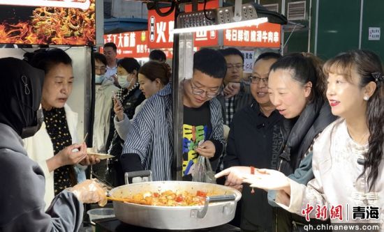 图为游客品尝美食。祁绣娟 摄