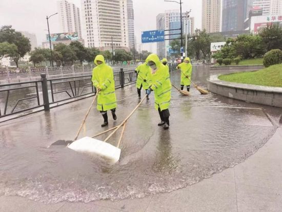 城中区市政公用服务中心防汛人员清理路面积水。季蓉 摄